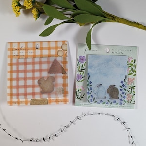 May include: Two packs of decorative washi tape featuring a squirrel and a pair of rabbits. The tape is labeled "Cookie" and "Fleur" with the text "Tracing Paper Stickers 40 sheets".