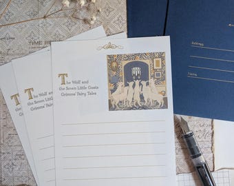 May include: Stationery set featuring lined paper with the title "The Wolf and the Seven Little Goats" and an illustration. Includes a navy blue envelope and a fountain pen. The paper has a decorative border.