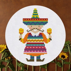 Puede incluir: Un patrón de punto de cruz colorido de una persona que lleva un sombrero y sostiene maracas. La persona lleva una camisa naranja brillante, un chaleco verde, azul y amarillo, y una falda roja, rosa y morada. El fondo es blanco.