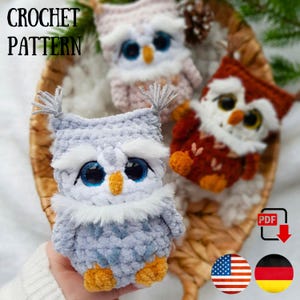 Op de afbeelding: Drie gehaakte uilenspeeltjes in een rieten mand. De uilen zijn in tinten grijs, roze en bruin, met grote blauwe ogen en pluizige witte accenten. De afbeelding bevat de tekst "CROCHET PATTERN" en een PDF-downloadpictogram.