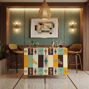 May include: A rectangular bar cabinet featuring a colorful geometric pattern with teal, yellow, and dark brown vertical panels. The cabinet doors display stylized starburst motifs and the text "good vibes only" in a cursive script font.