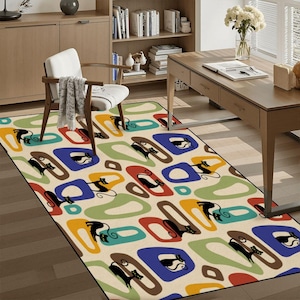 May include: A rectangular area rug with a cream background and a repeating pattern of black cat silhouettes within colorful, abstract shapes. The shapes include blue, red, green, and yellow, creating a mid-century modern aesthetic.