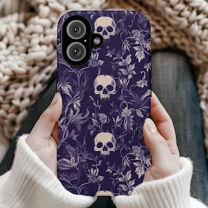 May include: Purple phone case with a white skull and floral pattern.