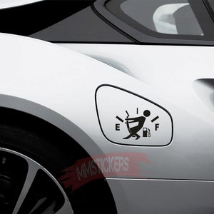 Puede incluir: Una pegatina de indicador de combustible de coche en blanco y negro con una figura de palo empujando una bomba de gasolina. La pegatina está colocada en la puerta del tanque de gasolina de un coche blanco. La pegatina dice "E" y "F" para vacío y lleno.