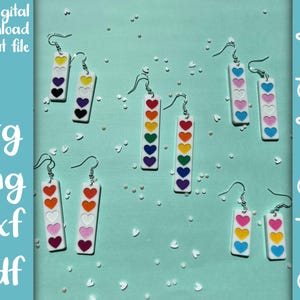 May include: Rainbow heart earrings with white background. Each earring has five hearts in a different color: red, orange, yellow, green, and blue. The earrings are available for digital download as a cut file in SVG, PNG, DXF, and PDF formats.