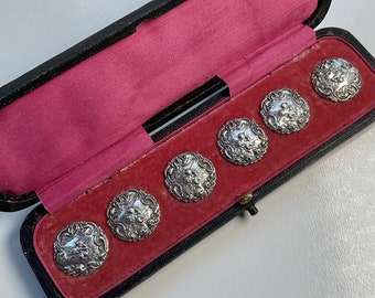 Boxed set of silver buttons.