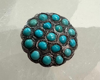 Silver hand worked button with turquoises.