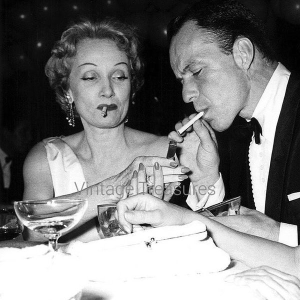 Marlene Dietrich zündet Frank Sinatras Zigarette an