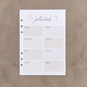 May include: A white weekly planner insert with six circular binder holes on the left side. The page features the text WEEKLY planner at the top, followed by seven rectangular boxes labelled Monday through Sunday, and a final box labelled Notes.