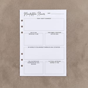 May include: A white paper manifestation planner insert with six punched holes along the left edge. The page features black text and boxes with prompts including Today I Want To Manifest, Why Is This Important To Me, and My Words To The Universe.