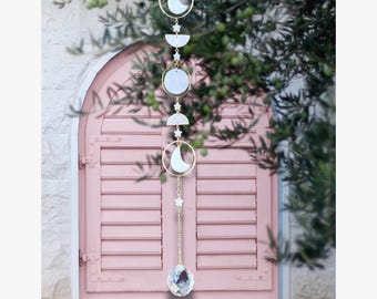 Acchiappasole lunare: conchiglia naturale con fasi lunari e stelle da appendere alla finestra.