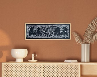 Può includere: Un mobile in legno marrone chiaro con una parte anteriore in rattan intrecciato e due ripiani aperti. Il mobile è decorato con una stampa incorniciata in bianco e nero di elefanti e un vaso con foglie di palma secche. Il mobile è davanti a una parete in terracotta con un arco che conduce a una sala da pranzo.