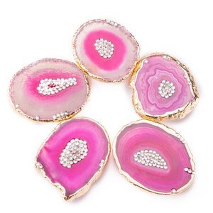 May include: Five pink agate coasters with gold trim and a cluster of rhinestones in the center of each.