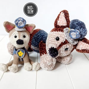May include: Two crocheted plush dog toys dressed as police officers. One dog is brown and white with a blue and white hat. The other dog is tan and white with a blue hat and a yellow star.