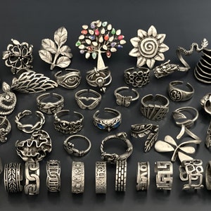 Peut inclure: Une collection de 35 anneaux de pied en argent avec différents motifs, dont un arbre, un tournesol, un papillon, une feuille, un cœur, un serpent et un dragon.
