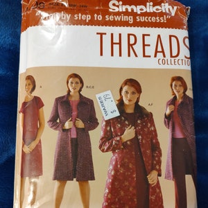 May include: A white ceramic mug with a black handle and the text "But First, Coffee" in a black, bold font. The mug is sitting on a white surface. The mug is approximately 4 inches tall.