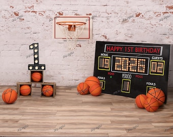 May include: A basketball-themed birthday scene with a scoreboard displaying "HAPPY 1ST BIRTHDAY." The scene includes basketballs, a basketball hoop, and a large number "1" with lights. The background features a brick wall and wooden floor.
