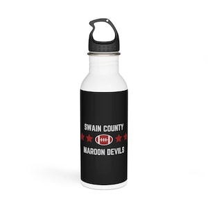 Puede incluir: Una botella de agua de acero inoxidable blanca con una tapa negra y un diseño en blanco y negro. El diseño presenta el texto "Swain County Maroon Devils" con un balón de fútbol rojo y cinco estrellas rojas.