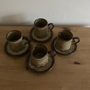 May include: Set of four brown and beige speckled ceramic coffee cups with matching saucers.