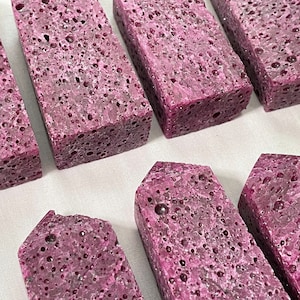 May include: Seven purple, porous, rectangular blocks with rounded edges. The blocks have a rough, textured surface.