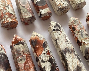 Könnte beinhalten: Eine Sammlung von zehn braunen, weißen und schwarzen Kristallspitzen aus natürlichem Stein. Die Spitzen sind alle unterschiedlich groß und geformt, aber sie haben alle ein ähnliches Muster aus weißen und braunen Wirbeln.