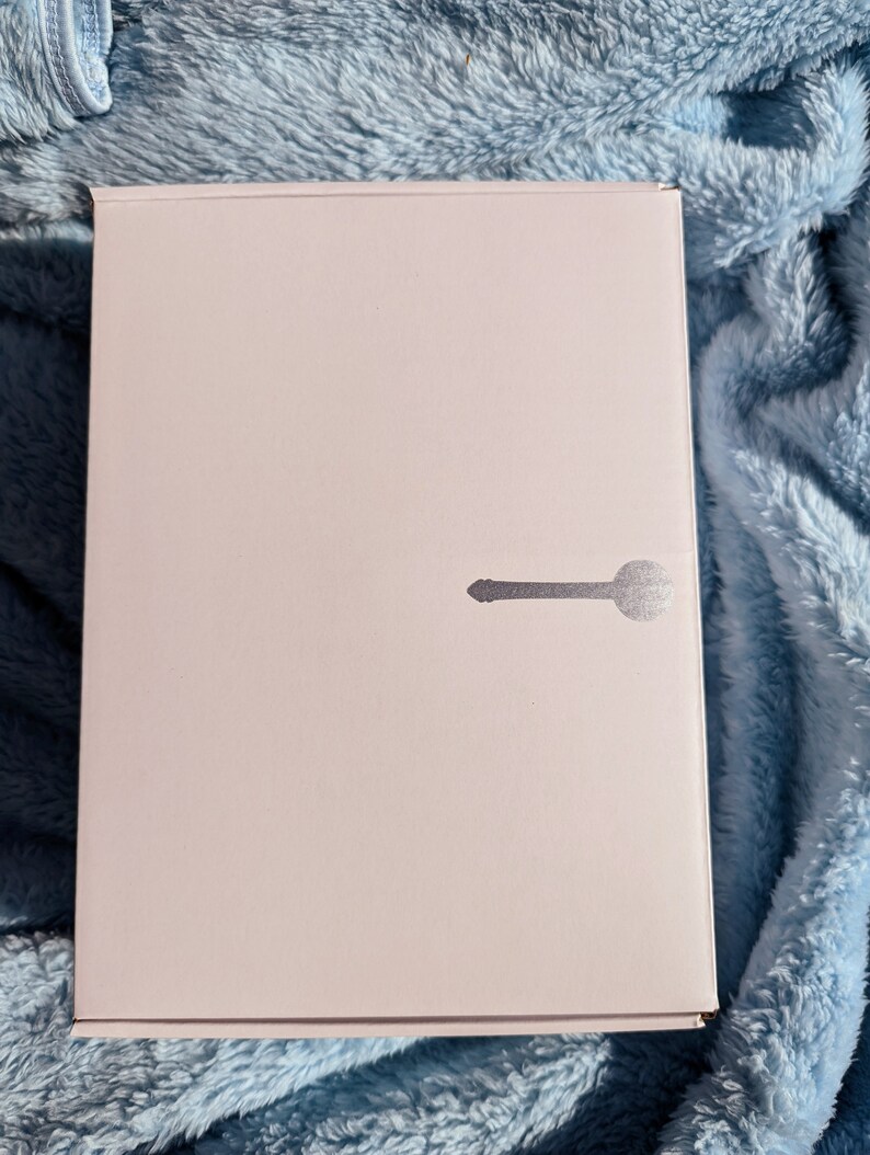 May include: A white box with a silver keyhole design on the front.