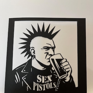 Punk Nostalgia : Echoes of Carlisle - Une carte captivante en papier découpé faite main, parfaite pour les amateurs de punk rock et les amateurs de nostalgie.