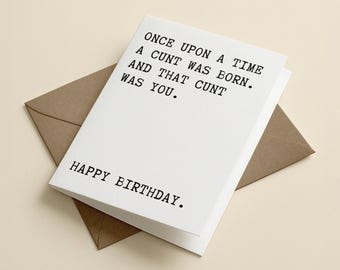 May include: A white greeting card with black typewriter-style text that reads: ONCE UPON A TIME A CUNT WAS BORN. AND THAT CUNT WAS YOU. HAPPY BIRTHDAY. The card is positioned on top of a brown envelope, displaying a clean and simple design.