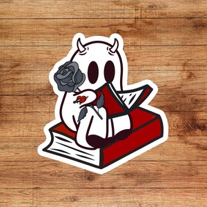 May include: A white ghost with horns holding a black rose and sitting on a red book with a white spine.