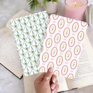 May include: Two patterned cards. One has a cream background with bluebell flowers and a scalloped border. The other features yellow flowers in pink oval frames with bows on a white background.
