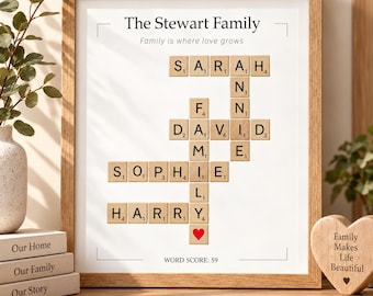 May include: A framed wall art print featuring a crossword-style arrangement of wooden letter tiles spelling out family names including Sarah, Annie, David, Sophie, and Harry. The text reads The Stewart Family, Family is where love grows, and WORD SCORE: 59.