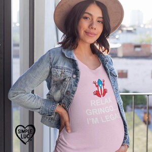 May include: A pink maternity t-shirt with a white Puerto Rican flag frog graphic and the text "Relax Gringo... I'm Legal".