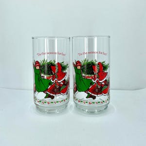 A Set of 2 Christmas Vintage &quot;Tis The Season For Fun&quot; Coca- Cola Limited Edition Beverage Glasses &quot;Holly and Robby Bringing In Tree&quot;