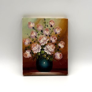 Puede incluir: Pintura al óleo de un ramo de rosas rosas y blancas en un jarrón verde azulado. Las flores están dispuestas en un grupo denso, con hojas verdes. El fondo pasa de verde claro a un marrón cálido.