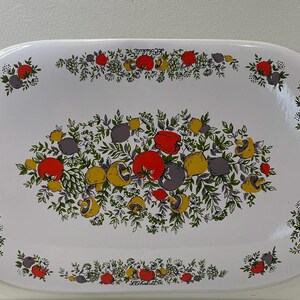 May include: White oval serving platter with a floral design featuring red, yellow, and green flowers and leaves. The border of the platter has a repeating pattern of the same floral design. The text "Le Printemps" is printed on the platter.
