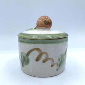 Plato de cerámica artesanal con tapa con detalle de pera: un recipiente rústico para guardar baratijas o un especiero de cocina.