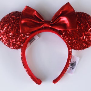May include: Red sequined Minnie Mouse ears headband with a red satin bow.