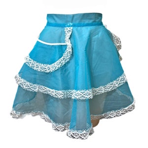May include: A turquoise blue apron with white lace trim and a white pocket. The apron has three tiers of lace.