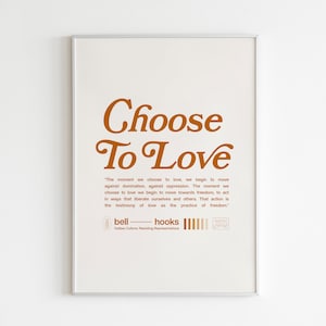 Peut inclure: Une impression encadrée avec le texte "Choose To Love" dans une police de caractères marron. La citation "The moment we choose to love we begin to move against domination, against oppression. The moment we choose to love we begin to move towards freedom, to act in ways that liberate ourselves and others. That action is the testimony of love as the practice of freedom." est imprimée sous le titre. La citation est attribuée à bell hooks.
