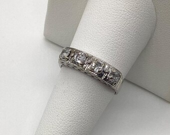 May include: A silver band ring with five clear round gemstones set in a row.