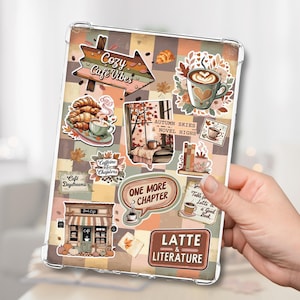 May include: A clear tablet case adorned with stickers of coffee cups, croissants, and autumnal leaves. Text includes "Cozy Cafe Vibes", "Autumn Skies & Novel Highs", "One More Chapter", and "Latte & Literature".