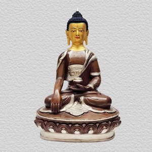Puede incluir: Una estatua de Buda de oro y bronce sentado en meditación con un cuenco en su regazo. La estatua está sobre una base de loto con intrincados detalles.