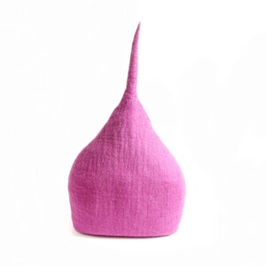 May include: A magenta hat with a conical shape and a long, pointed tip. The hat has a textured surface and is set against a white background. The hat appears to be made of felt.