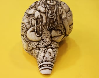 Trompeta tibetana tallada a mano en concha de caracola con grabado del dios Shiva.