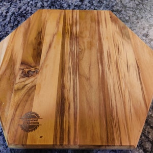 A back view of a hexagon shaped cutting board, with our logo laser engraved.
