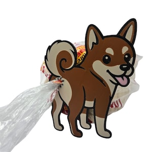 May include: A brown and cream-colored Shiba Inu dog-shaped waste bag dispenser. The dispenser is made of a sturdy material and features a smiling dog with a pink tongue. A clear plastic bag extends from the dog's rear.
