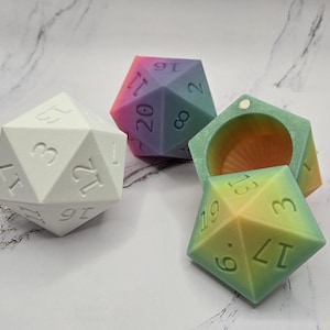 May include: Three iridescent dice, one white, one pink and purple, and one green and yellow. The dice are all 20-sided and have numbers 1-20 on each side.