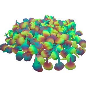 May include: A pile of colorful, abstract objects with a bulbous base and a stem. The objects are primarily yellow, green, and purple, with a gradient effect. The objects are scattered, creating a visually interesting composition.