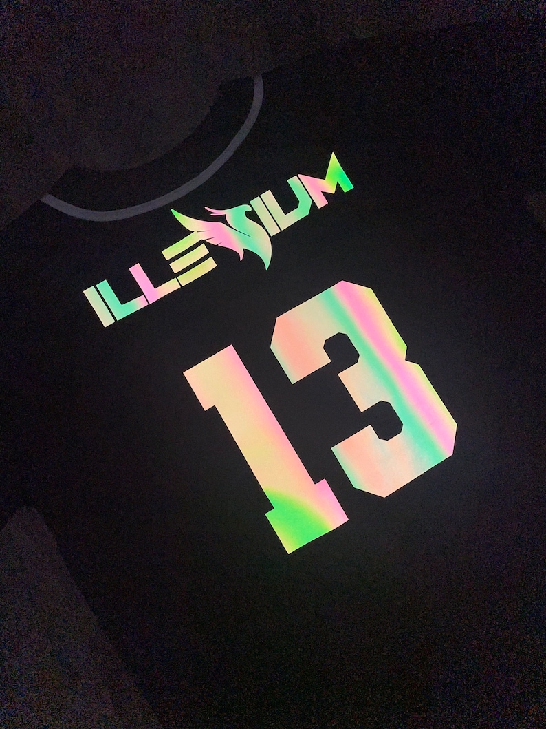 May include: Black baseball jersey with iridescent lettering and a number 13. The lettering says "ILLESIUM".