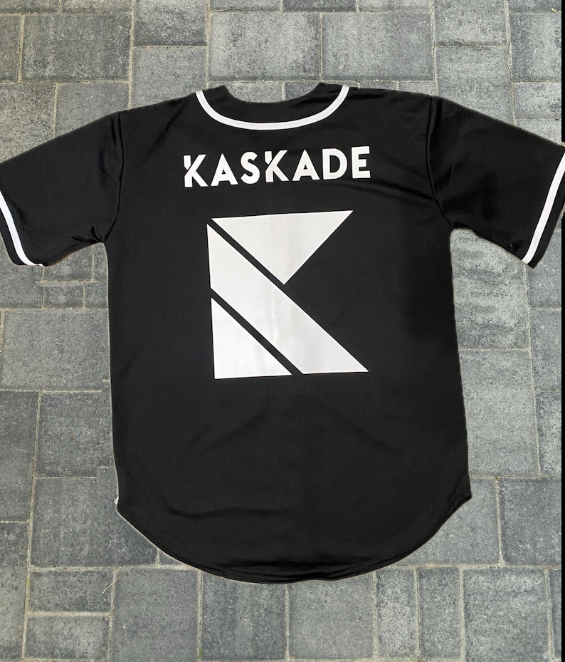 May include: Black baseball jersey with white trim and the word "KASKAIDE" printed on the back, along with a white geometric K logo.